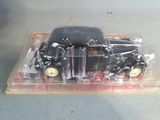 a black toy car in a clear plastic container