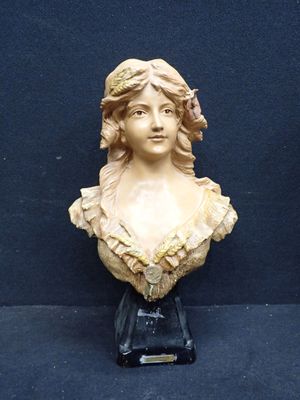 statue d'une femme avec une fleur dans les cheveux, posée sur un fond noir