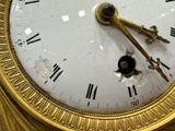 a gold clock with roman numerals on the face