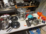 de nombreuses casseroles et poêles posées sur une table dans la cuisine