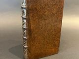 an old book sitting on top of a table next to a gray background