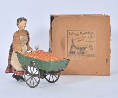 a figurine of a woman pushing a cart of carrots