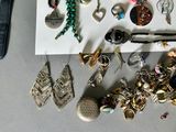 a lot of jewelry sitting on a table next to a watch