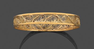 gros plan d'une bague en or sur une surface noire