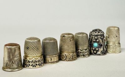 several thimbles are lined up in a row on a white surface