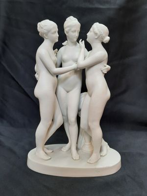trois statues blanches représentant trois femmes se tenant par la main sur un fond noir