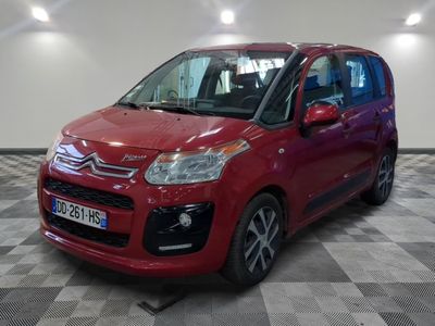 la petite voiture rouge est garée sur un sol en damier