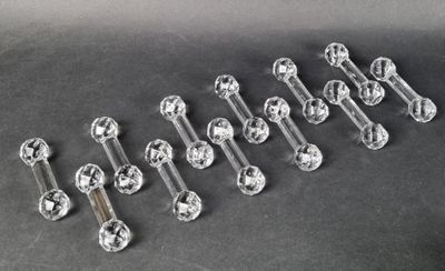 six clear glass knobs on a black surface with a black background