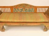 a wooden bench with a green cushion on it