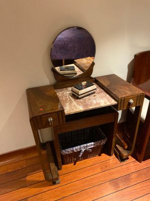 a small table with a mirror on it and a chair next to it