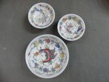 three bowls and a bowl with designs on them sitting on a table