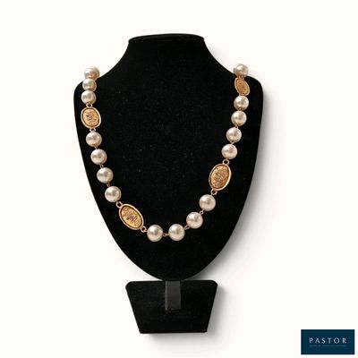 un collier composé de perles et de pièces d'or sur un mannequin noir