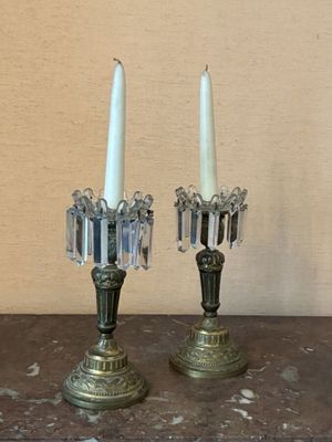pair of antique brass candlesticks with crystals on top of a wooden table