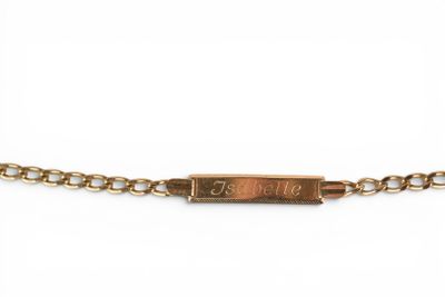 a close up of a gold chain bracelet with a small bar on it