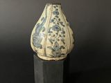 a blue and white vase sitting on a wooden stand