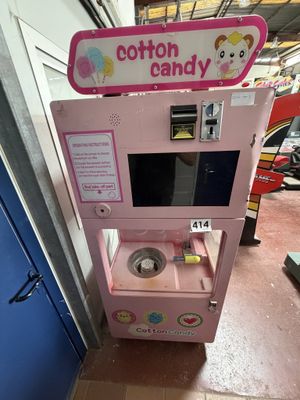 une machine rose sur laquelle est accrochée une pancarte indiquant « barbe à papa »