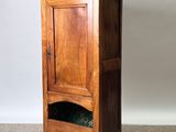 a tall wooden cabinet with a door on top of it