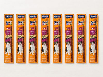 four large dog chew sticks are lined up on a white surface