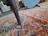 a red rug on the floor with a mirror in the background