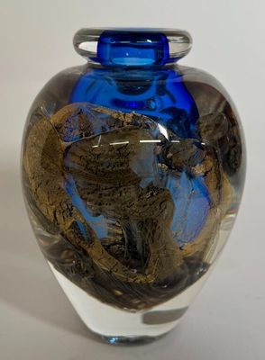 a blue glass vase with a dragon design on it