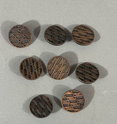 several metal buttons are arranged on a white surface