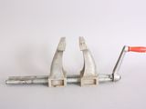 two clamps that are attached to a piece of metal