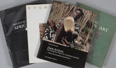 Trois livres sur l'art africain sont posés sur une table