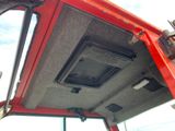 a red truck with a speaker in the back of it ' s cab