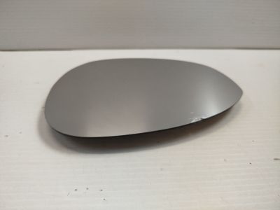 une souris argentée posée sur une surface blanche