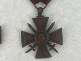 two medals and a cross on a white surface
