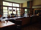 tables and chairs in a restaurant with lots of bottles on the counter