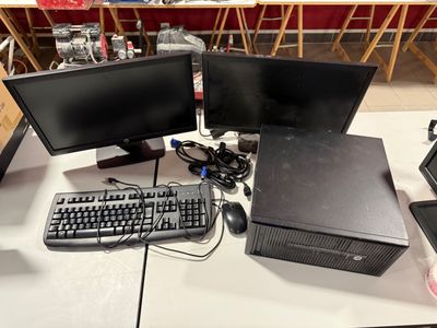 three computer monitors and a keyboard on a table