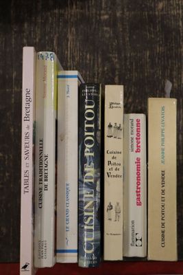 de nombreux livres posés sur une étagère posée sur une table