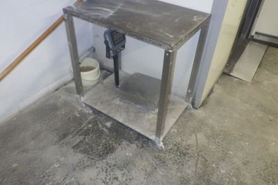 une table en métal sur laquelle est posé un seau, dans une pièce