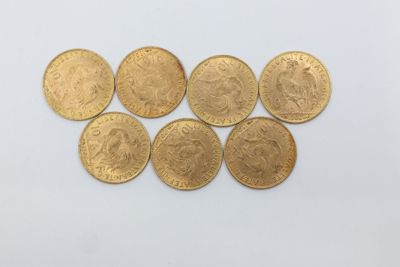 un tas de pièces d'or posé sur une surface blanche