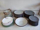 many plates and bowls sitting on a shelf