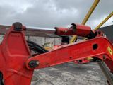a red excavator that is parked in a parking lot
