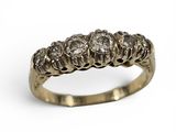 gros plan d'une bague en or et diamants sur fond blanc
