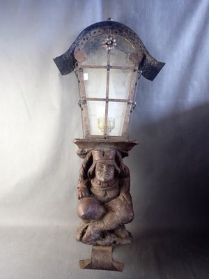 a statue of a man holding a lamp on his head