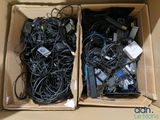 two cardboard boxes filled with electronic devices and wires sitting on top of each other