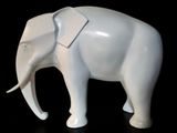 a white elephant that is standing on a black surface