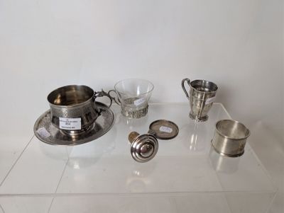 a lot of silver items sitting on a glass shelf