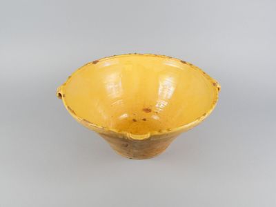yellow ceramic bowl on a white surface with a gray background