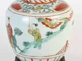 un vase orné d'une peinture, posé sur un socle