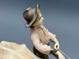 a figurine of a boy on a horse pulling a rope