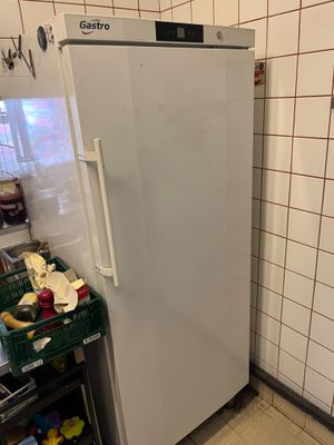 a white refrigerator in a kitchen with tiled walls