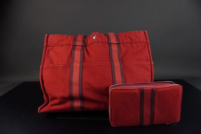 un sac et un portefeuille à rayures rouges et noires posés sur une surface noire