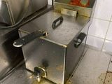 un sol sale dans une cuisine professionnelle sur lequel se trouve une friteuse