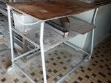 a table and chair in a kitchen with a stove in the background