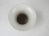 a white vase with a brown substance in it